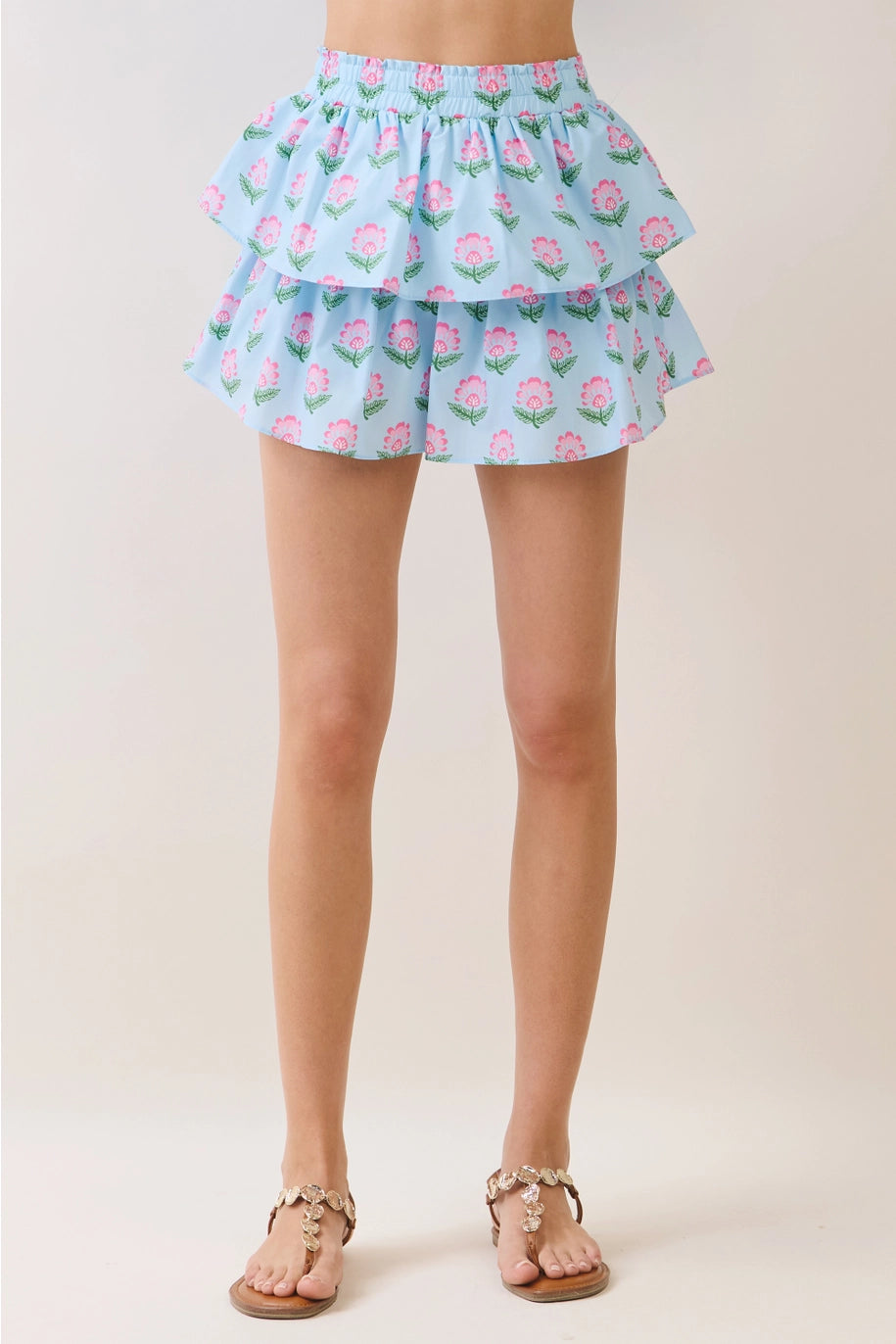 Light blue floral ruffled skirt worn by a person on a plain background