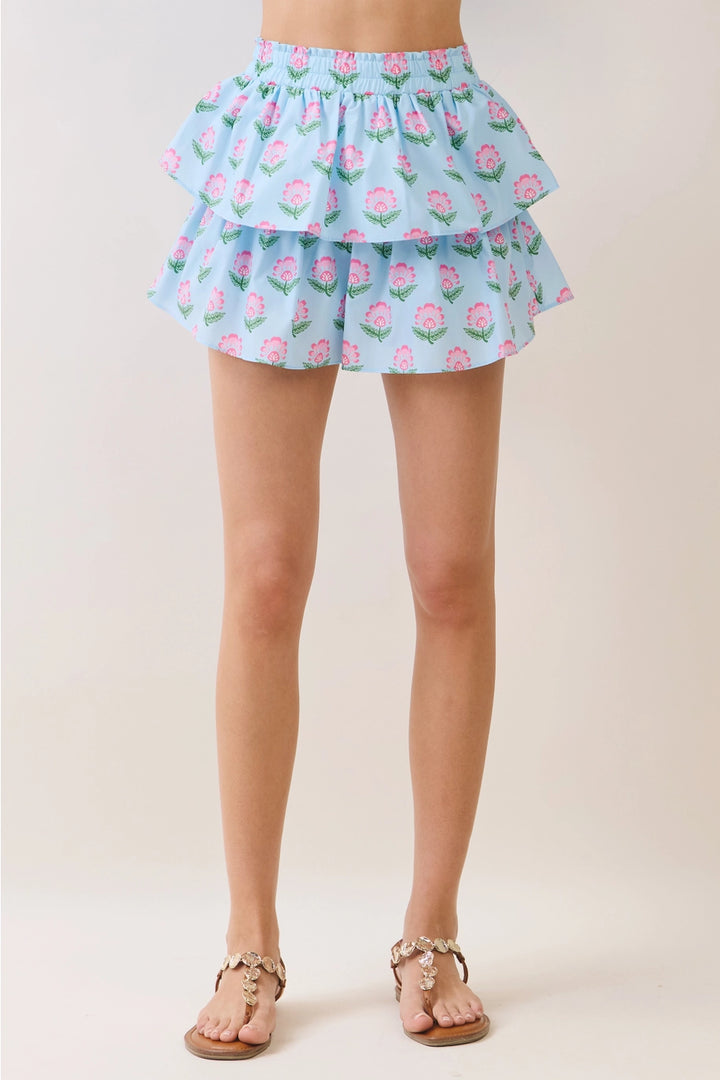 Light blue floral ruffled skirt worn by a person on a plain background