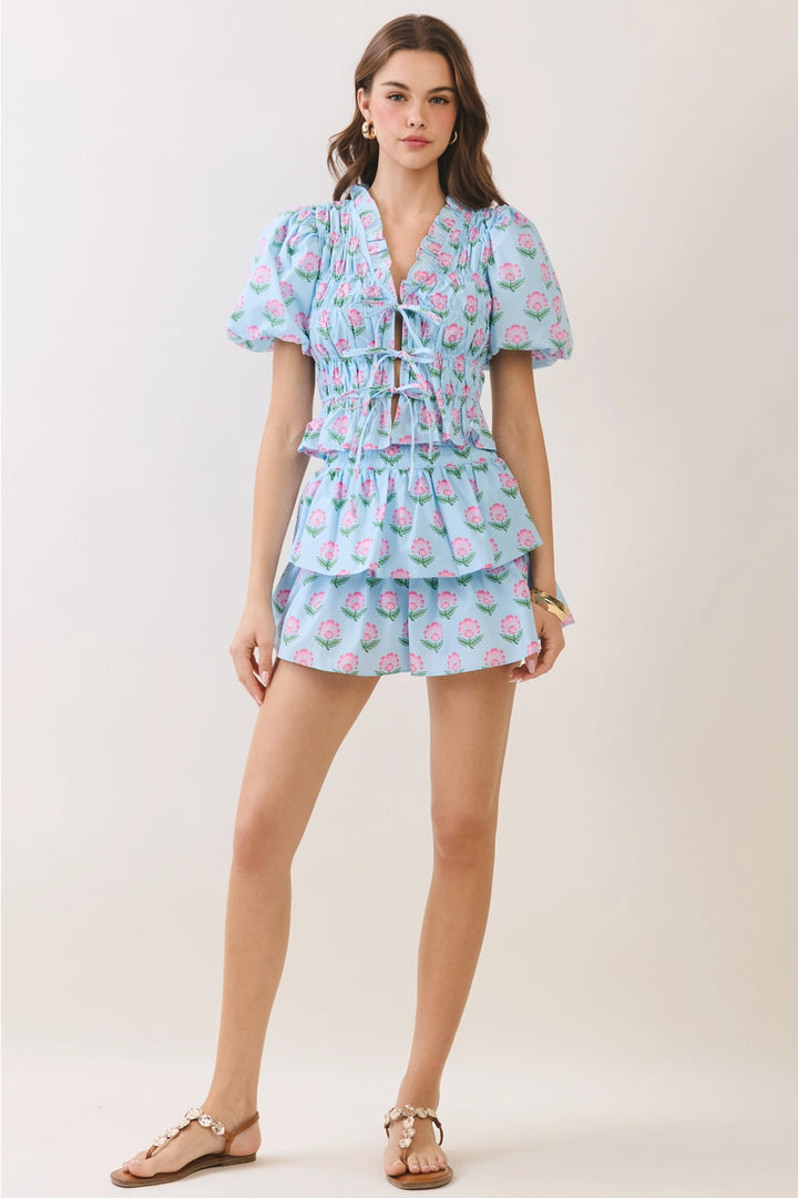 Woman wearing a light blue floral dress on a white background