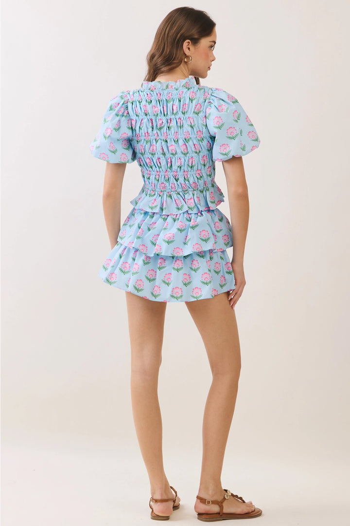 Woman wearing a light blue floral dress on a white background