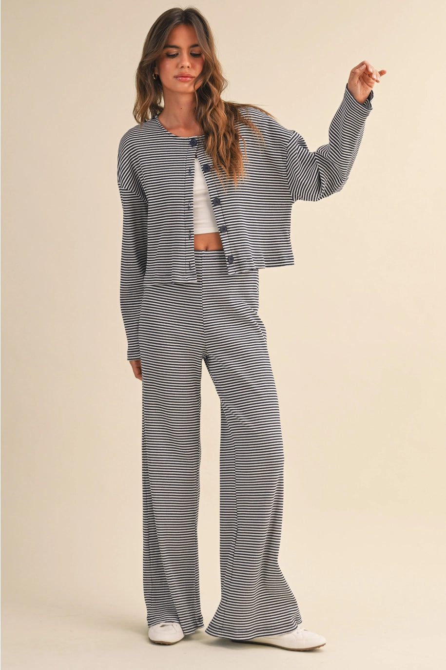 Woman wearing a navy and white striped outfit on a beige background