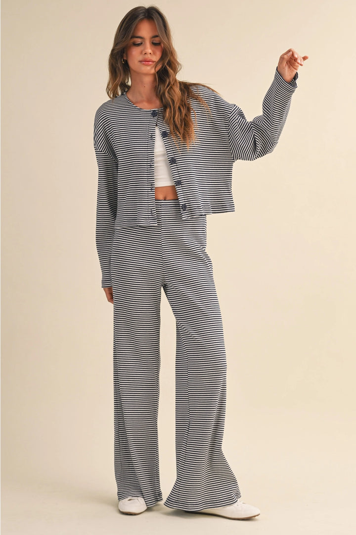 Woman wearing a navy and white striped outfit on a beige background
