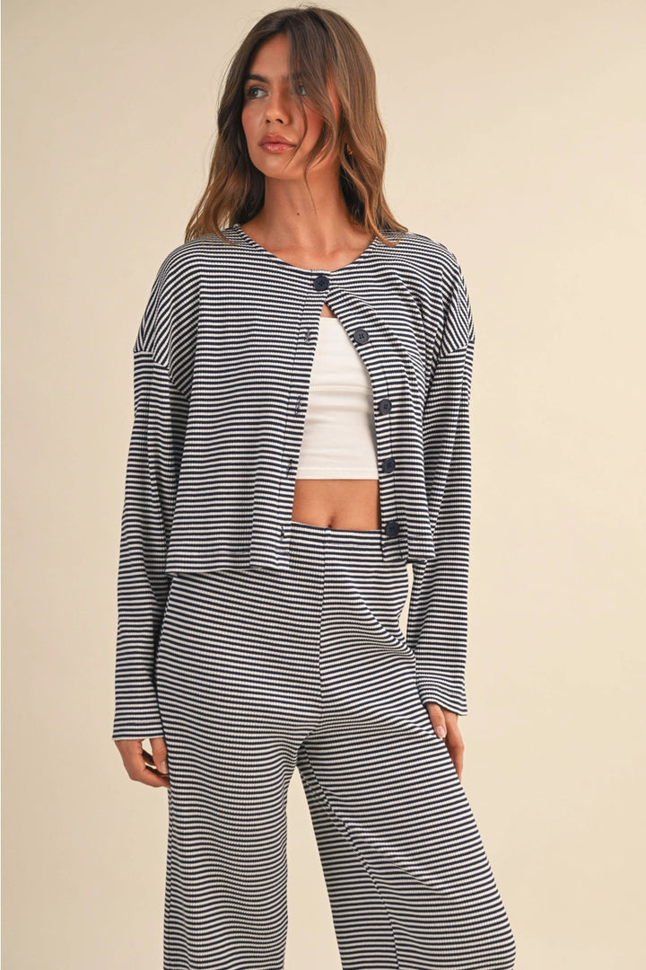Woman wearing a navy and white striped outfit on a beige background
