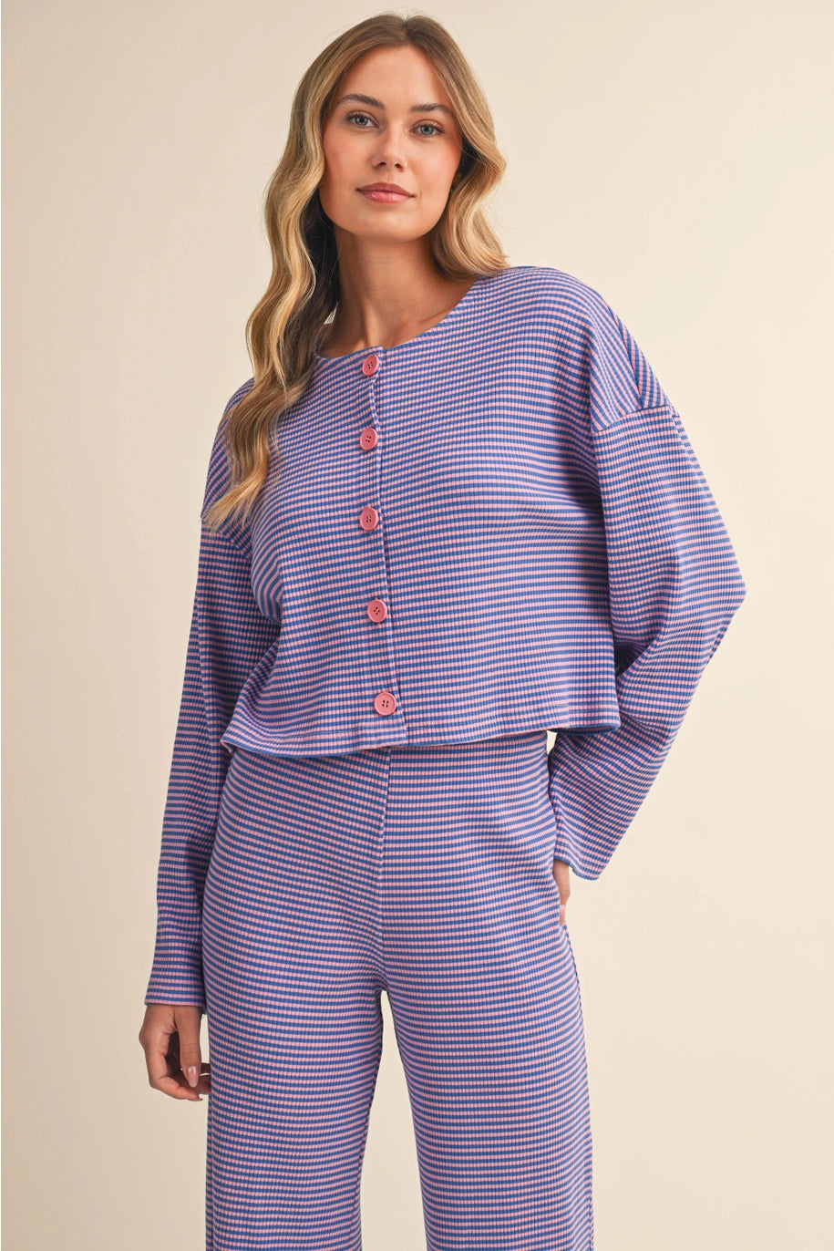 Woman wearing a purple striped outfit on a beige background