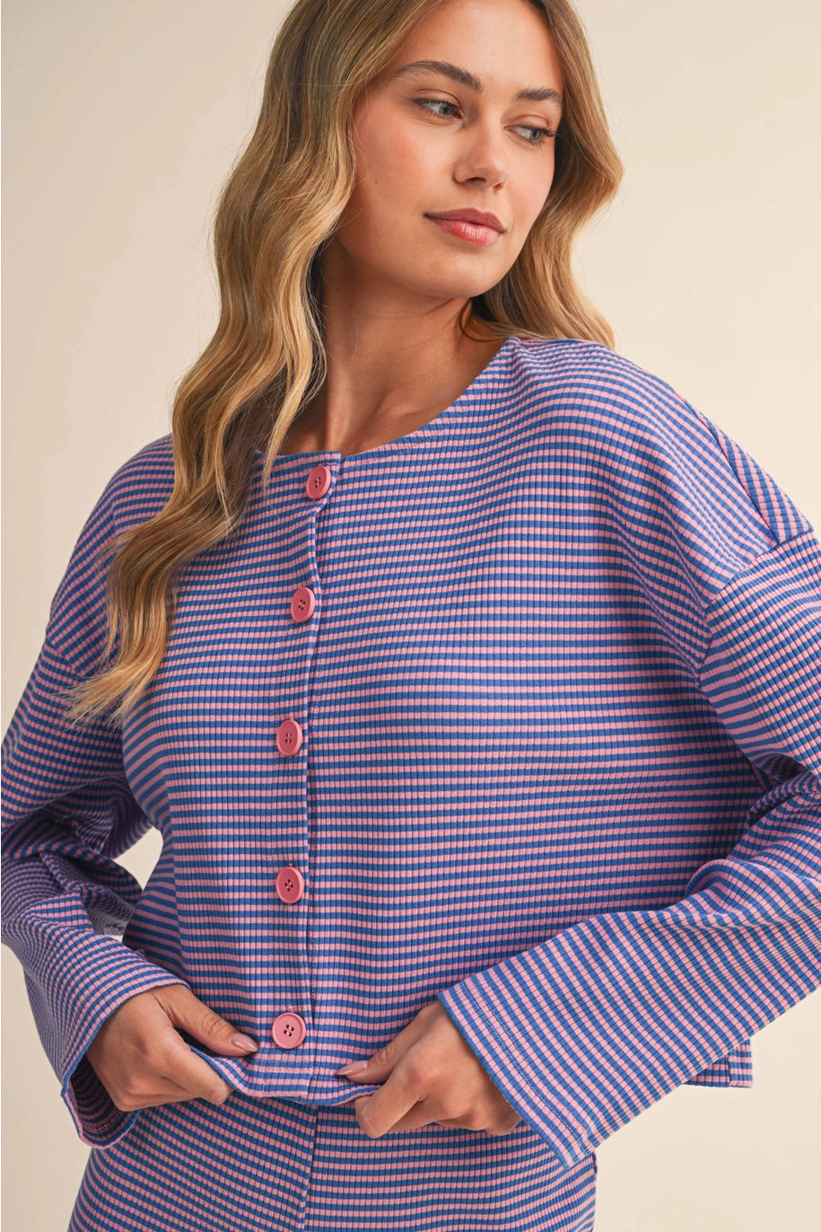 Woman wearing a blue and white checkered outfit with pink buttons on a beige background