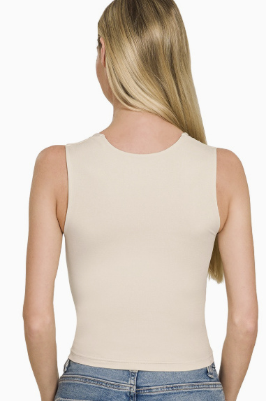 Woman wearing beige tank on white background