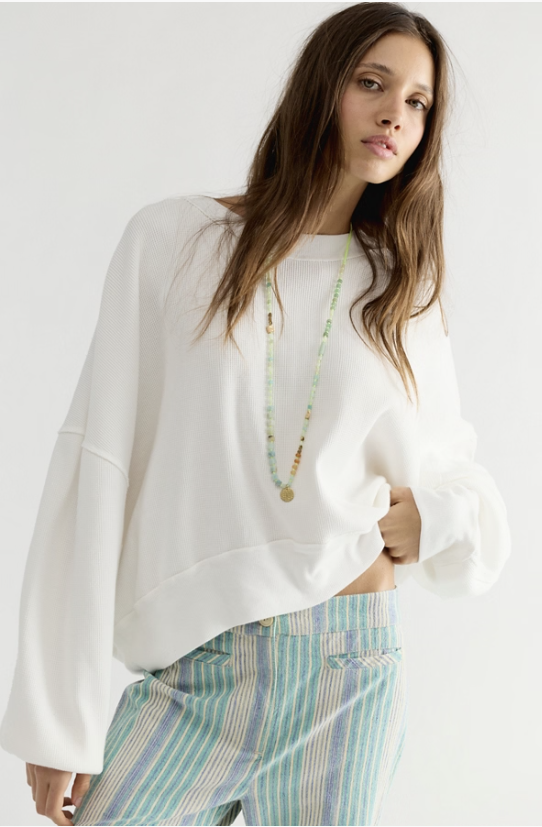 Woman wearing white long sleeve and stripe pants on white background