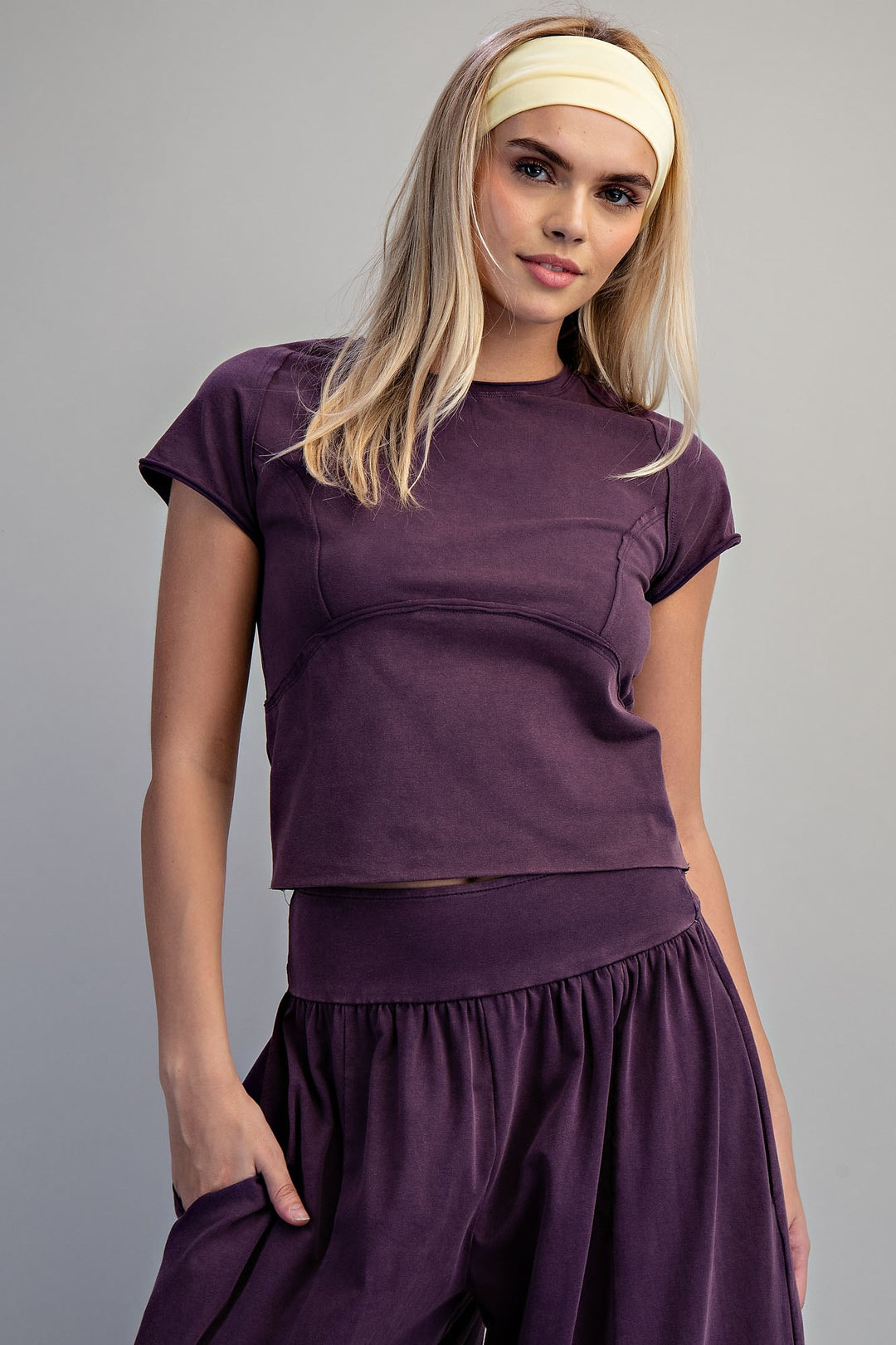 Woman wearing a purple outfit with a plain background