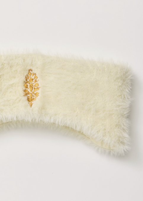 Cream sherpa headband with yellow logo on white background