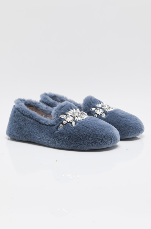 A pair of dusty blue fuzzy slip-on slippers with silver rhinestone snowflake embellishments on the top, photographed on a clean white studio background.