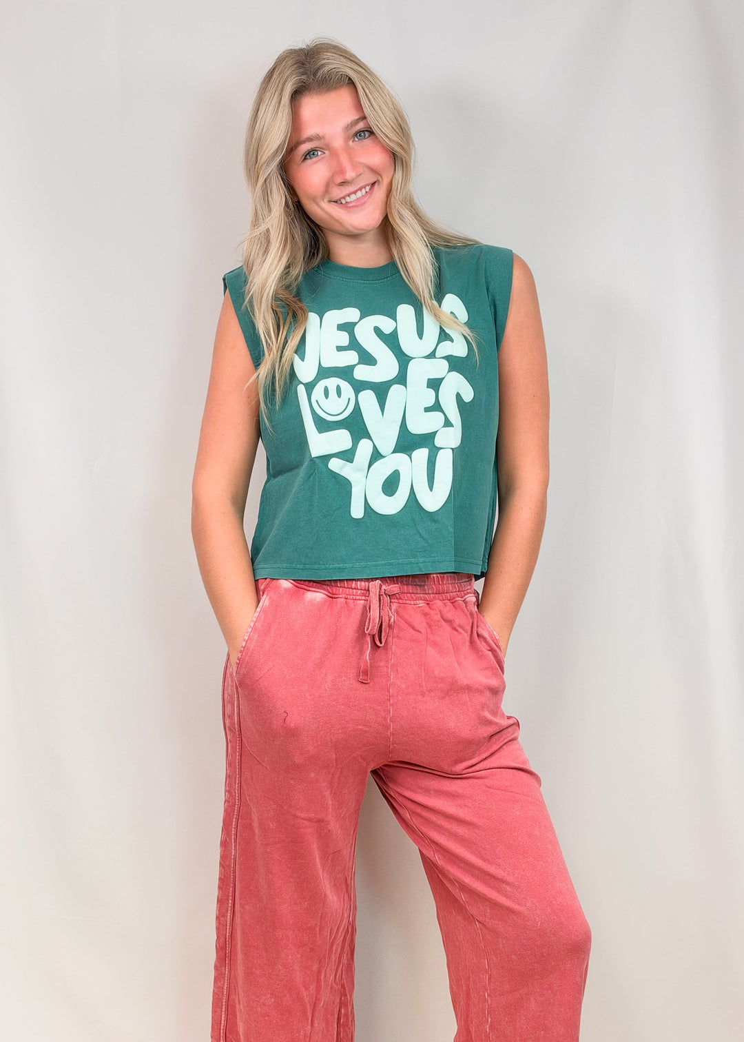 Woman wearing teal muscle tee with &