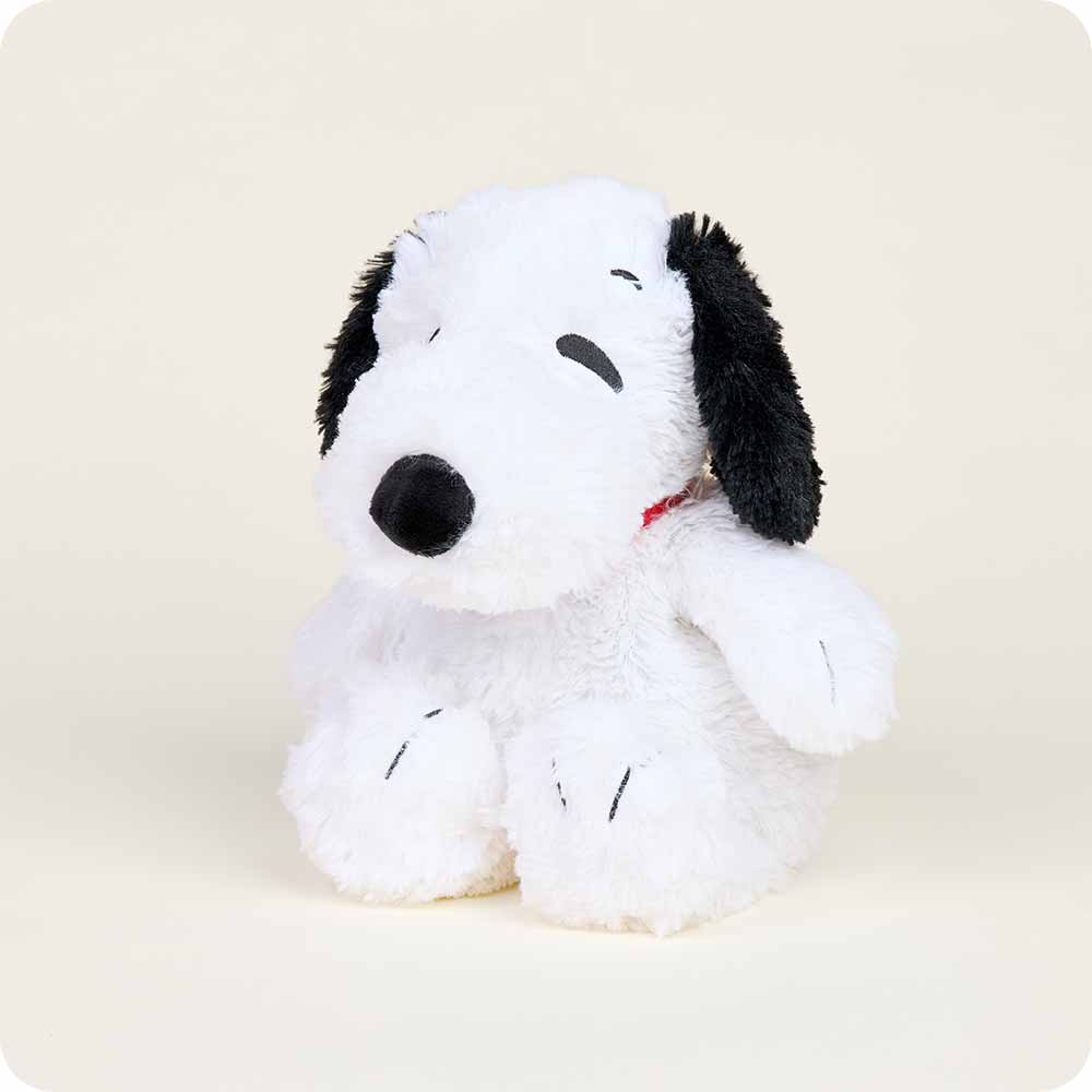 Plush toy resembling a black and white dog with a red collar on a beige background
