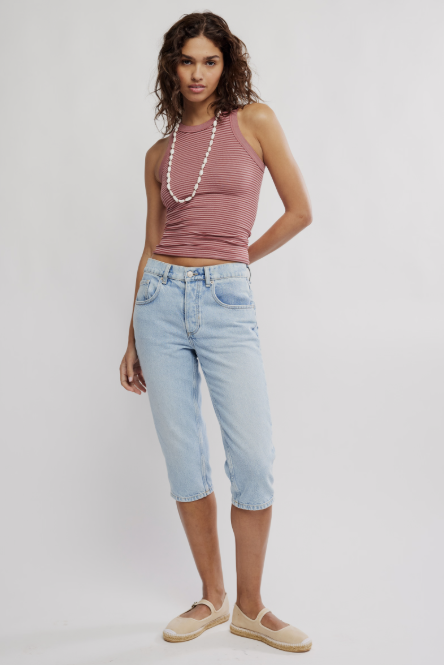 Woman wearing rose stripe tank and crop pants on plain background