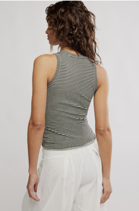 Woman wearing black and white stripe tank on plain background