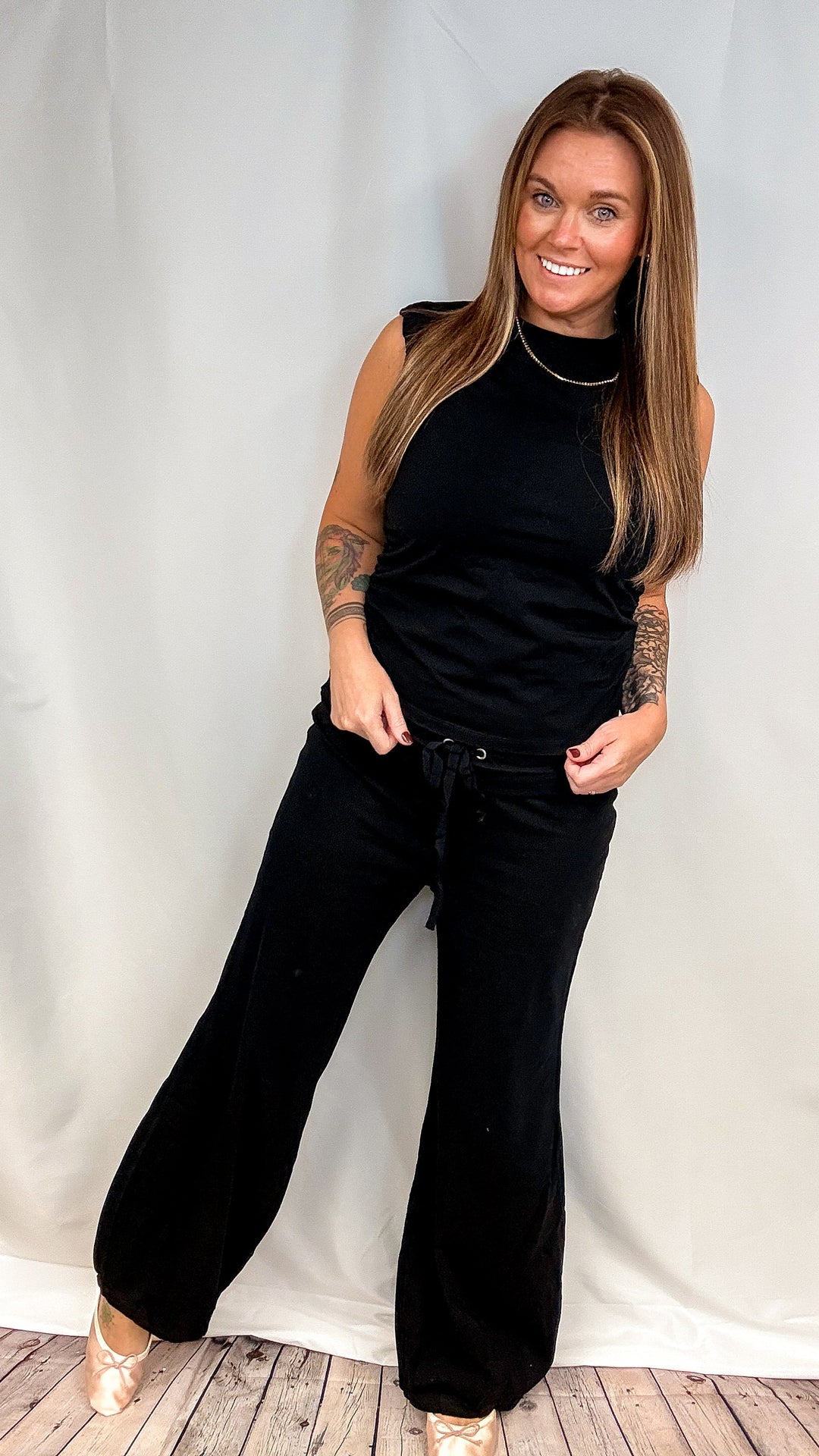 Woman wearing black matching set on plain background