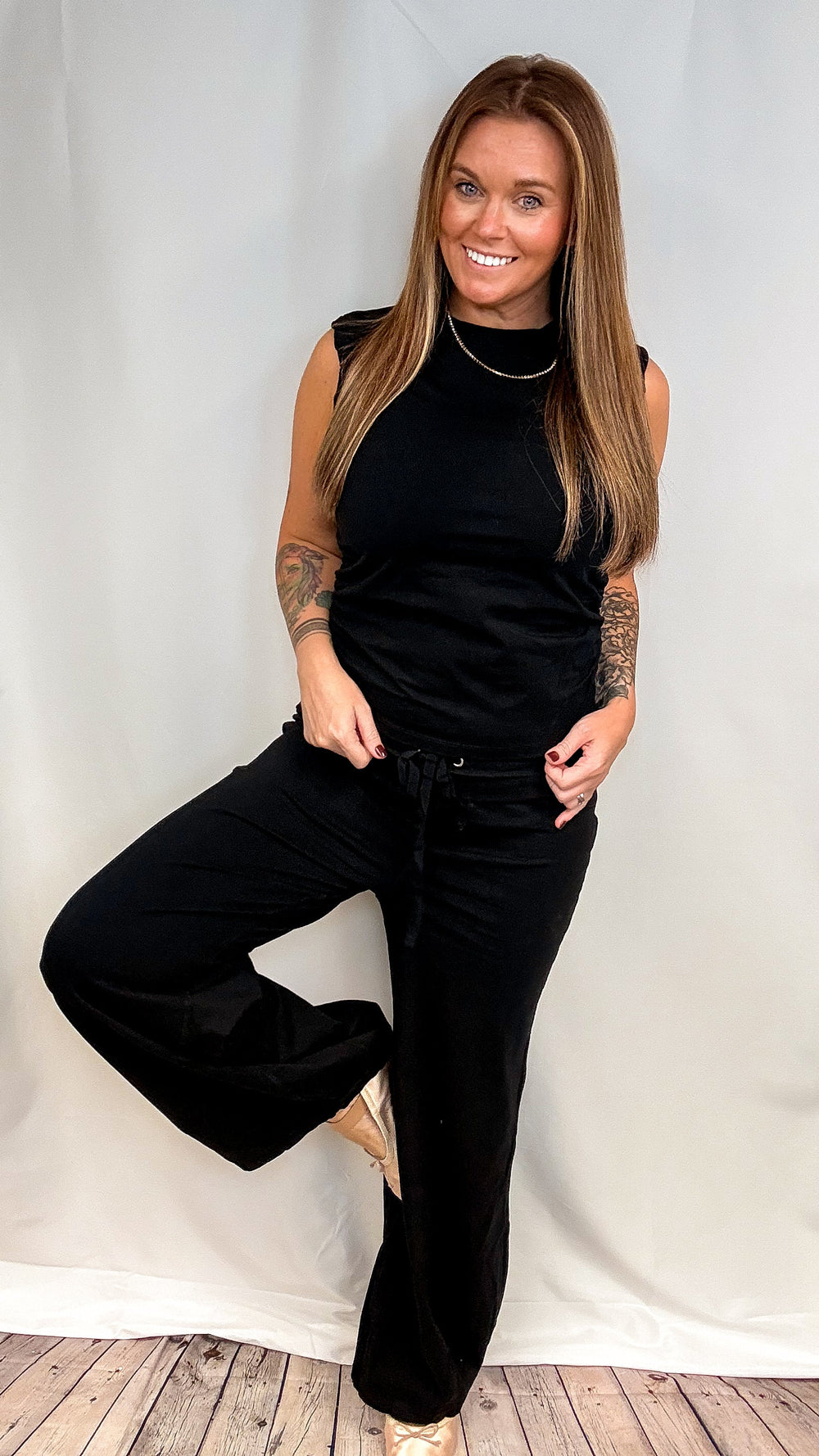 Woman wearing matching black set on plain background