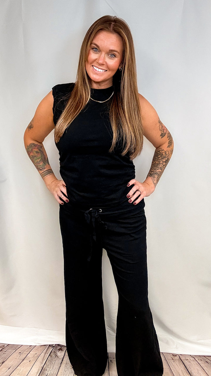Woman wearing matching black set on plain background