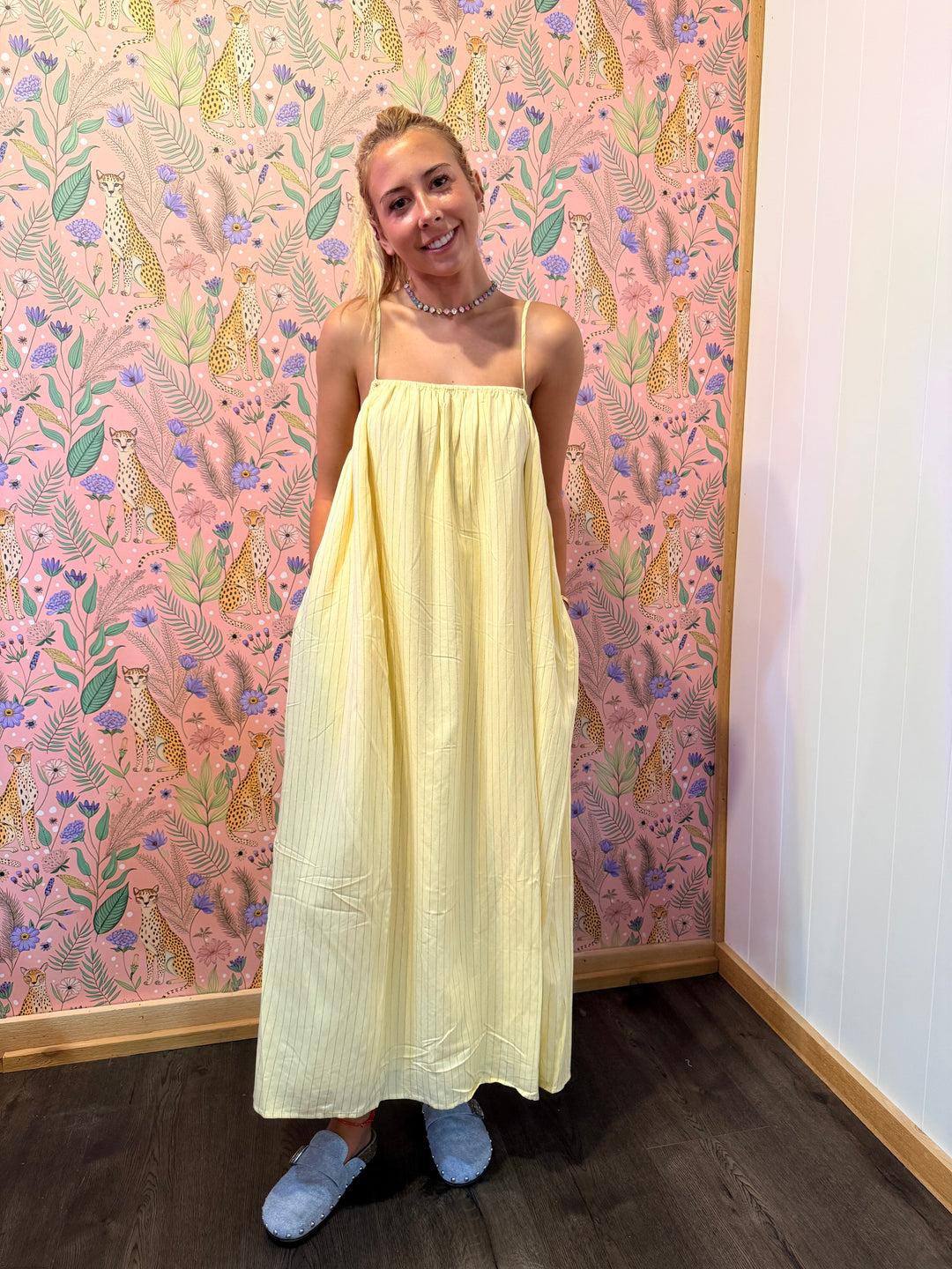 Woman wearing yellow pinstripe dress on floral background