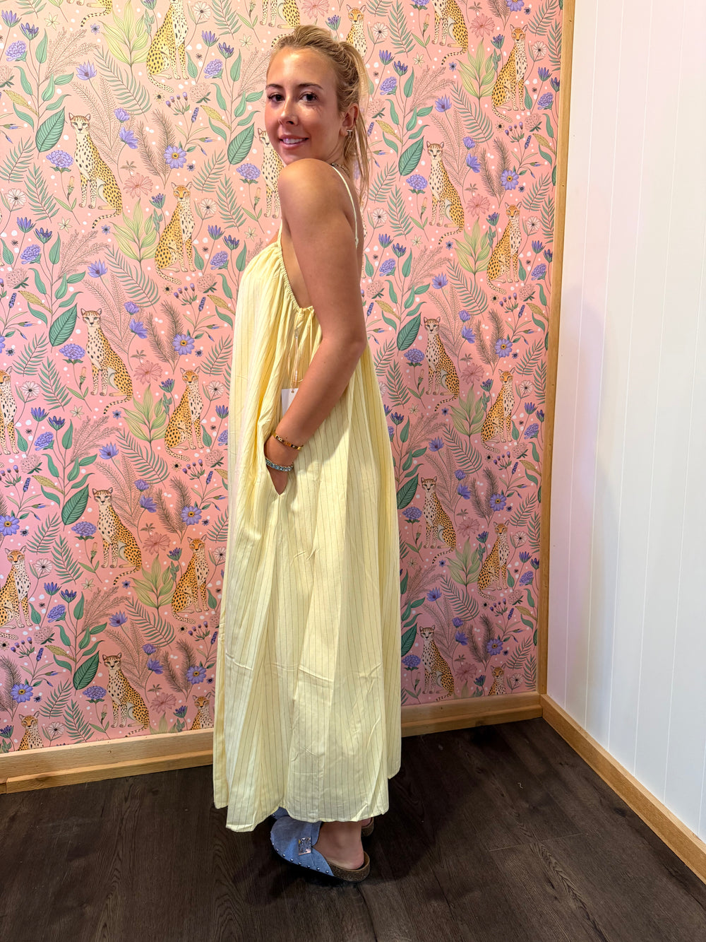Woman wearing yellow pinstripe dress on floral background