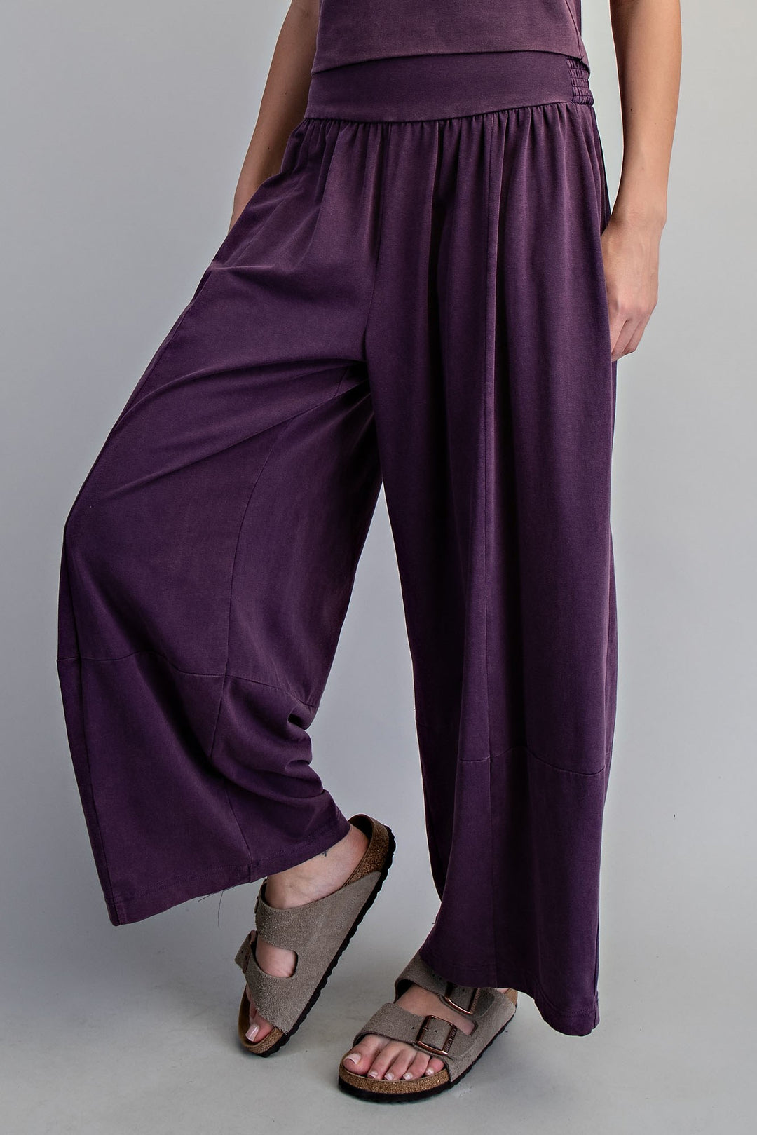 Woman wearing purple pants on plain background