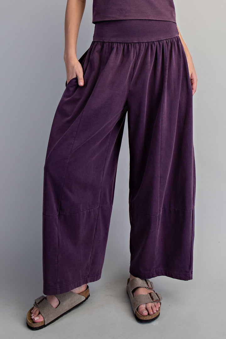 Woman wearing purple pants on plain background