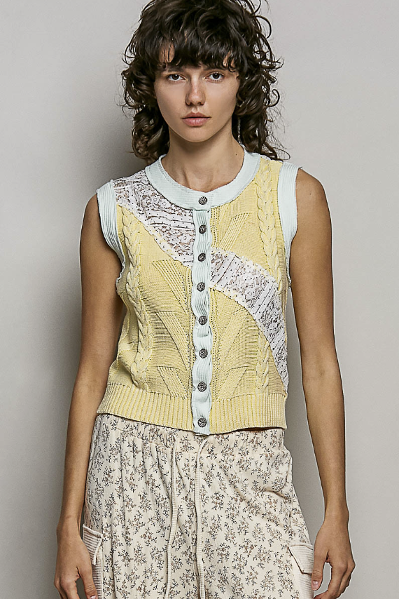 woman wearing yellow vest with light blue trim on plain background