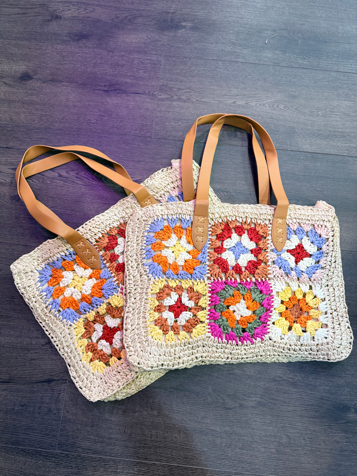 Crocheted bag with floral patterns on a wooden surface