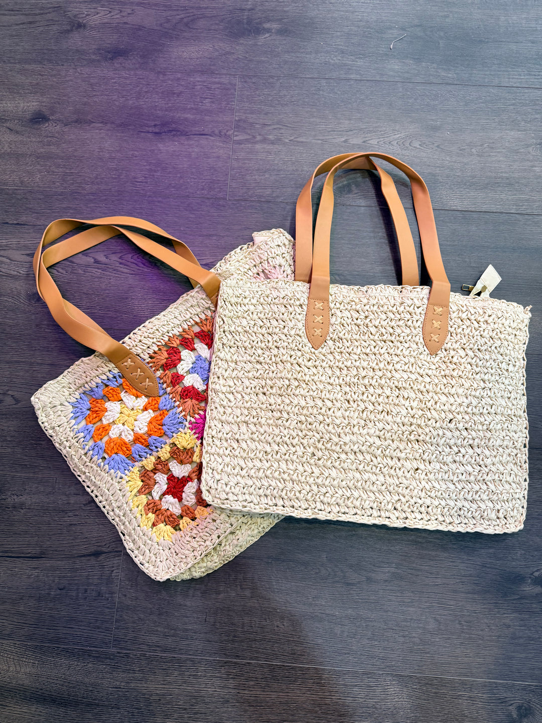 Woven bag with leather straps and a colorful crochet blanket on a wooden surface