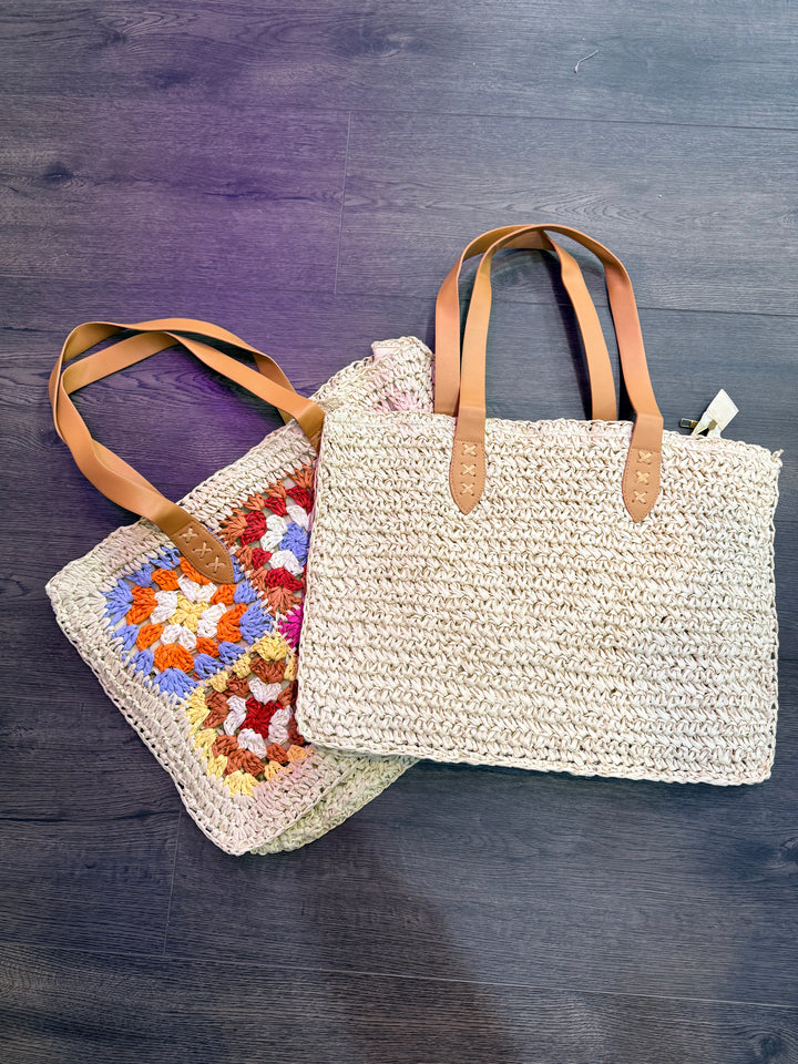 Woven bag with leather straps and a colorful crochet blanket on a wooden surface