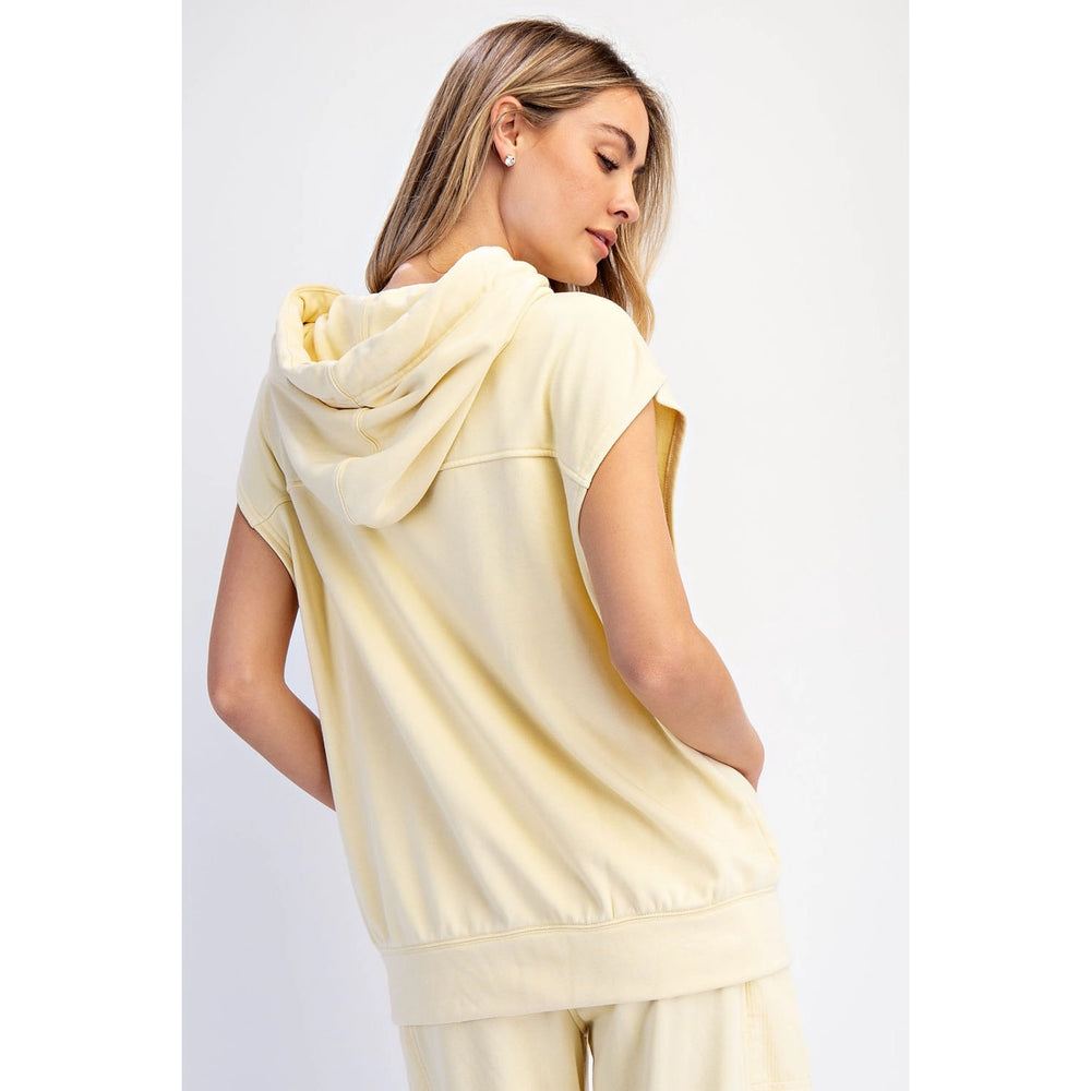Woman wearing a light yellow hoodie and pants on a white background
