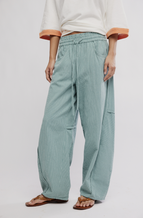 Person wearing light green striped pants on a plain background