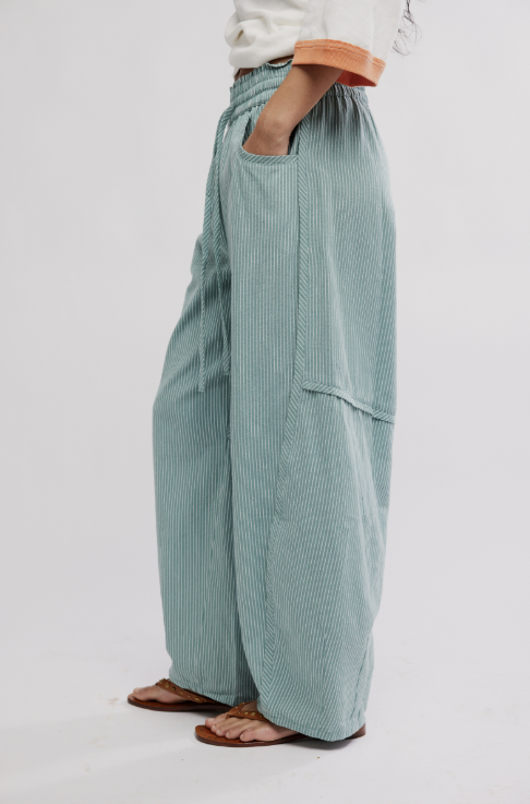 Green striped pants worn by a person on a white background