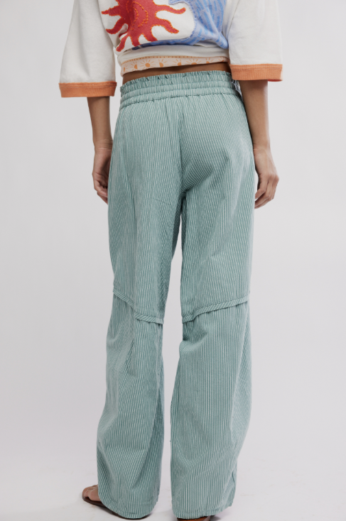 Person wearing light green striped pants on a white background