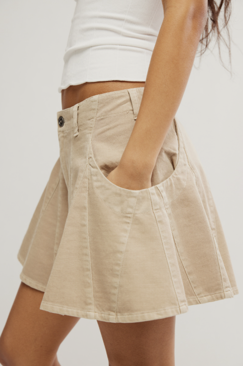 Beige shorts worn by a person on a plain background