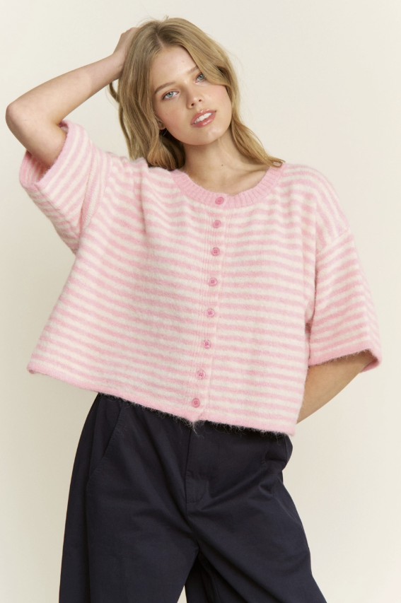 Woman wearing a pink striped shirt with a plain background