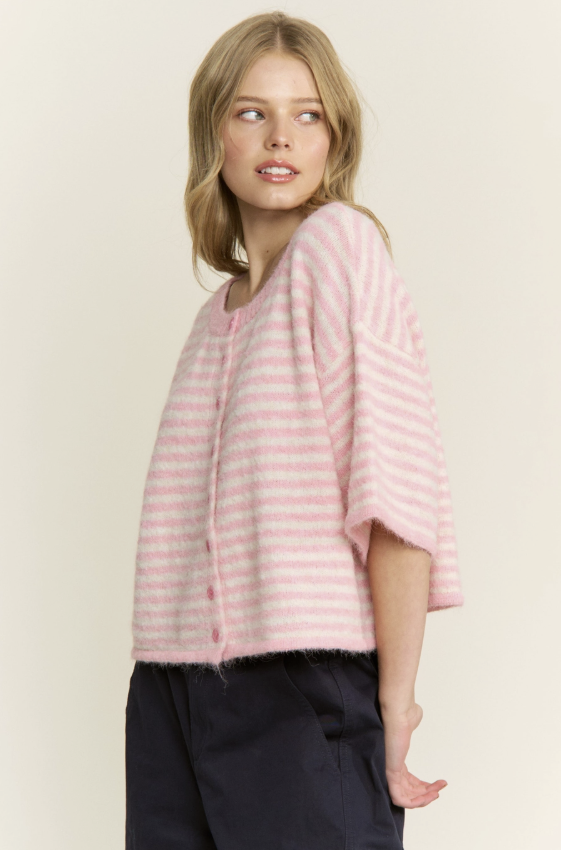 Woman wearing a pink striped sweater against a plain background