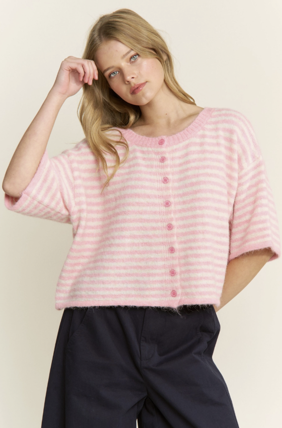 Woman wearing a pink striped sweater against a plain background
