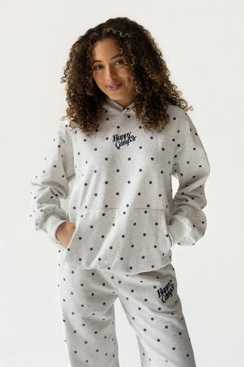 Woman wearing grey polka dot sweat suit on white background