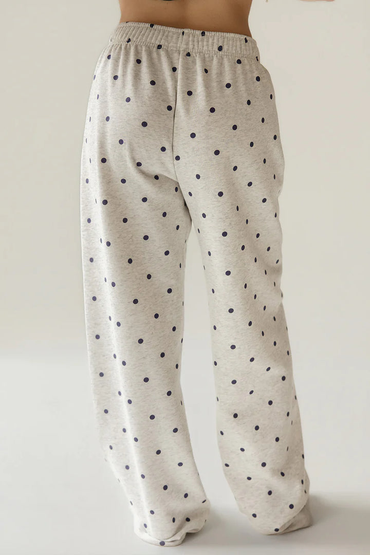 Beige pajama pants with black polka dots on a plain background