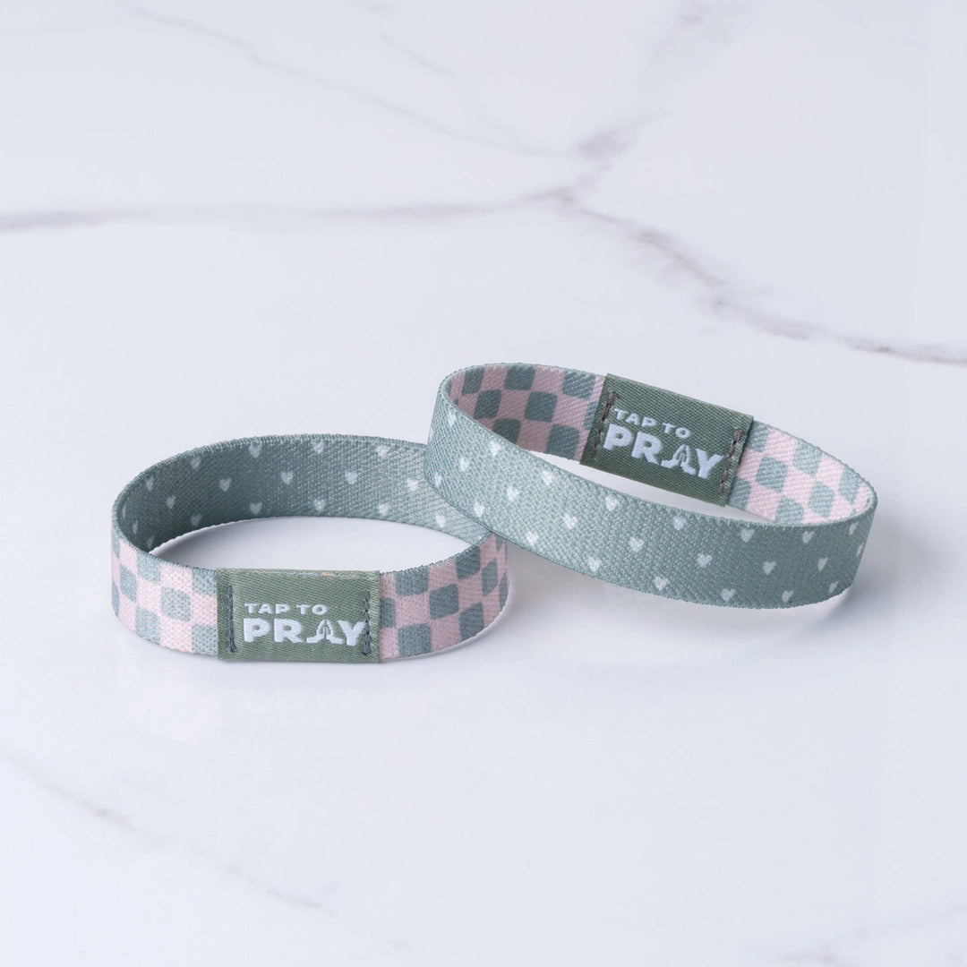 Two woven wristbands with checkered and patterned designs on a white background