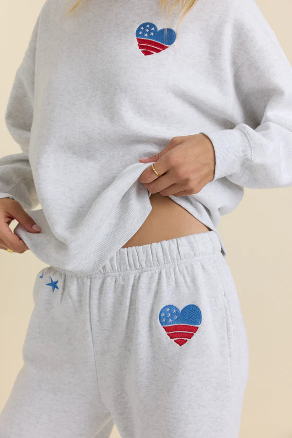 Gray sweatshirt and pants with heart-shaped American flag design on a beige background
