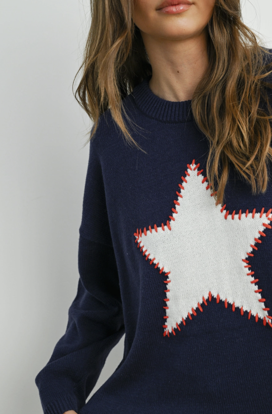 Navy sweater with a large white star design on a plain background