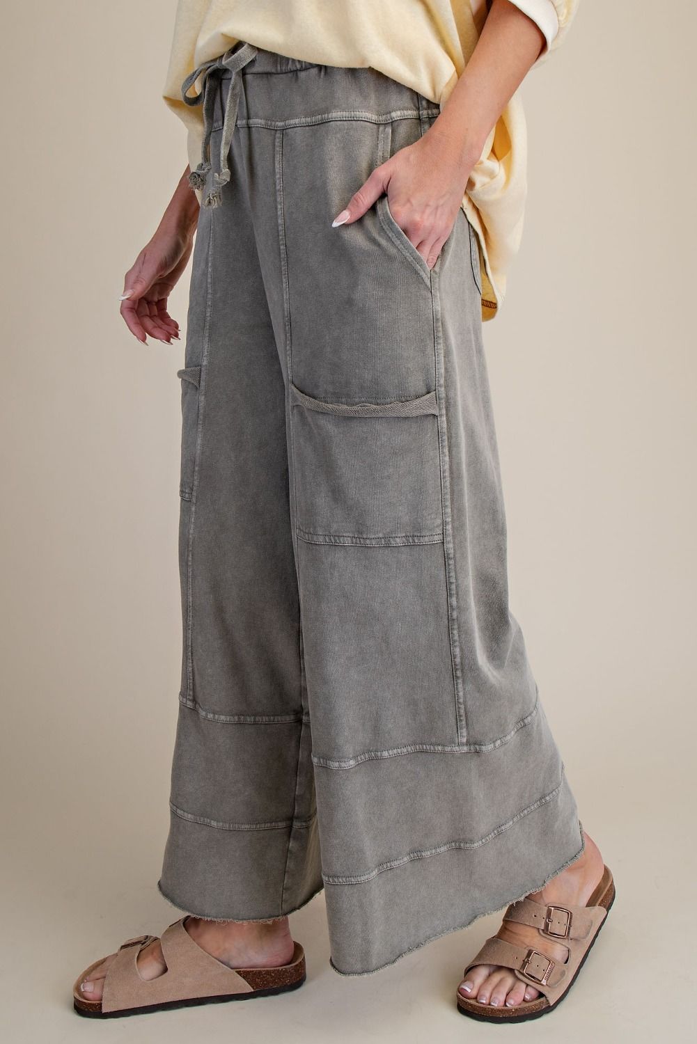 Person wearing wide-leg gray pants with a neutral background