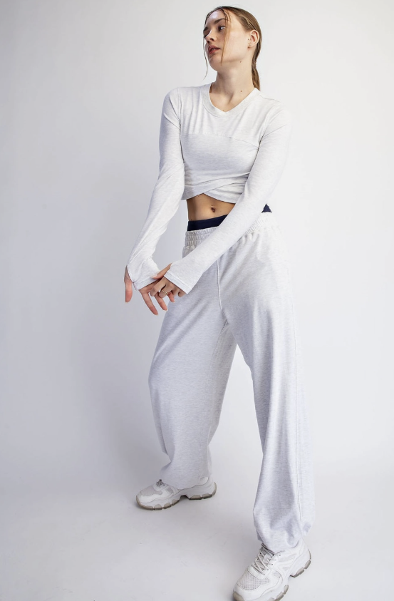Woman wearing matching light heather grey lounge set on plain background