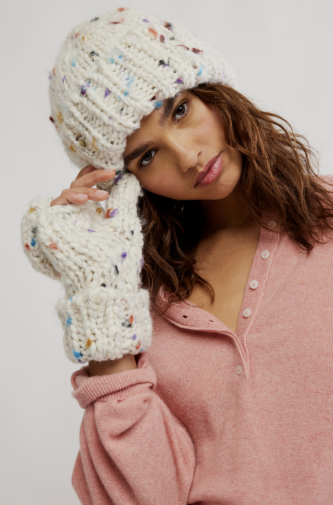 Woman wearing beige chunky knit beanie and convertible mittens on white background