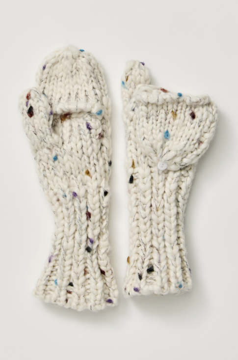 A pair of chunky knit fingerless mittens in an off-white cream yarn with multicolored flecks, laid flat on a light gray background.