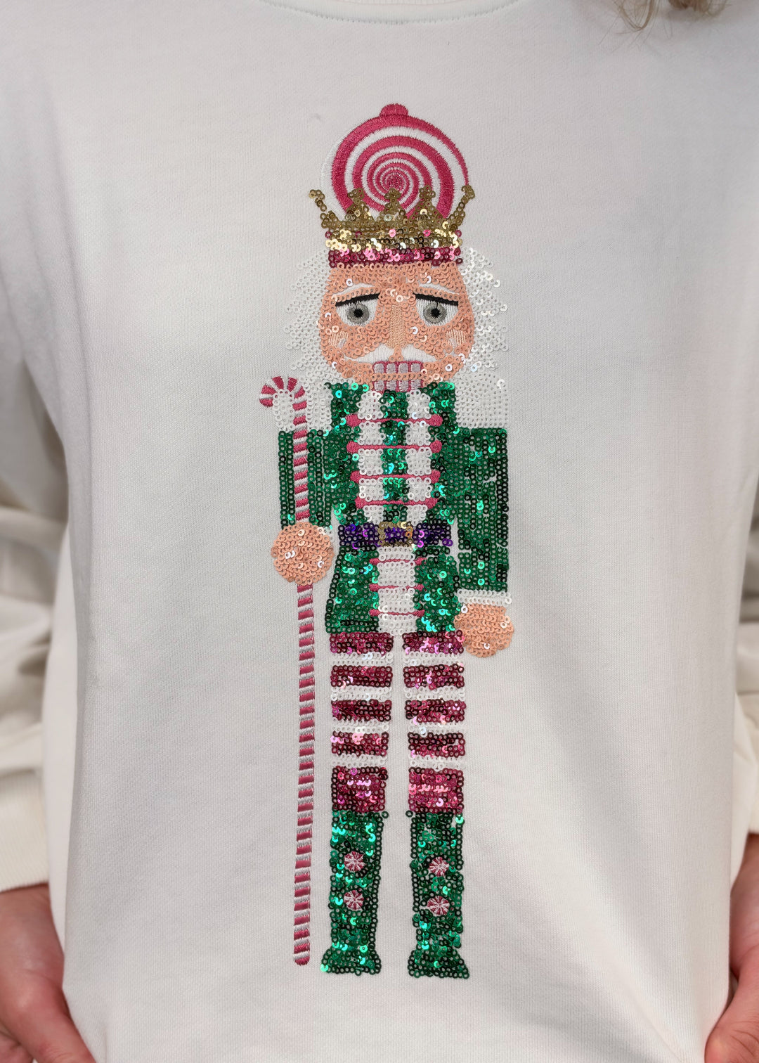 Close up of white sweatshirt with sequin nutcracker