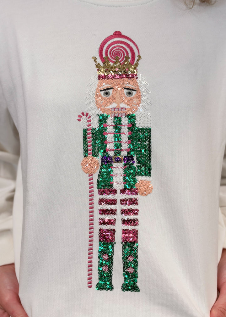Close up of white sweatshirt with sequin nutcracker