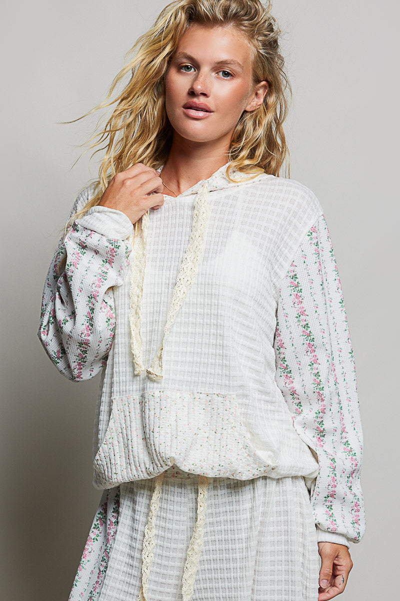 woman wearing white waffle knit hoodie on plain background