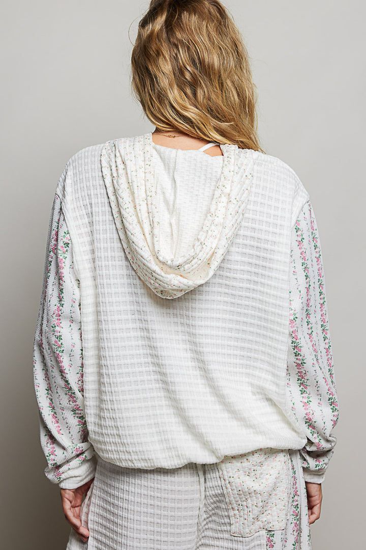woman wearing white waffle knit hoodie on plain background